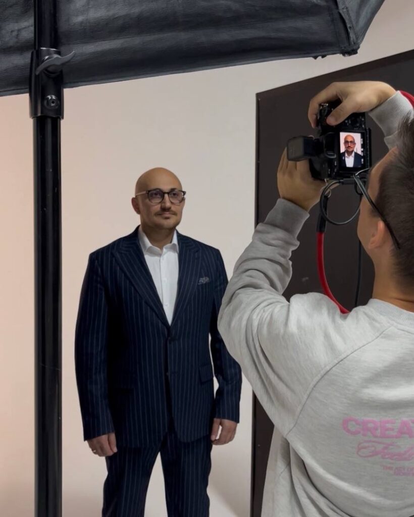 Адвокат в костюме на съёмке портрета, фотограф с камерой на переднем плане